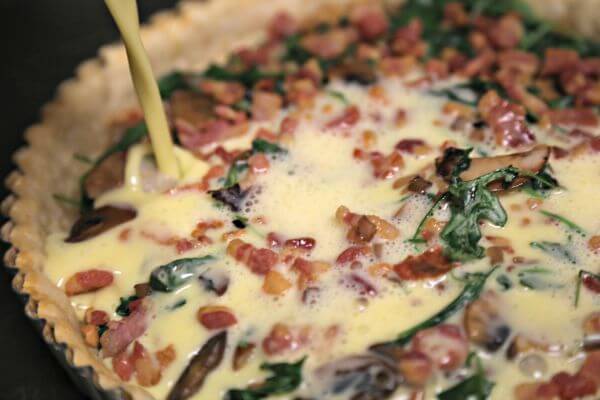 Smoky Pancetta Quiche - Adding the Custard | CookingInStilettos.com