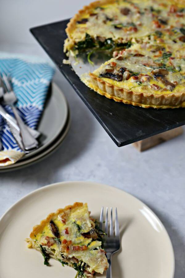 This Smoky Pancetta Quiche from CookingInStilettos.com is perfect for brunch, lunch or even dinner. Crisp pancetta, fresh arugula and buttery mushrooms are baked in a cheesy egg custard that will have your guests swooning with every bite. | Pancetta Quiche | Homemade Quiche | Breakfast for Dinner | Brunch Recipe | Quiche Recipe | Bacon Quiche | Breakfast | Brunch Quiche 