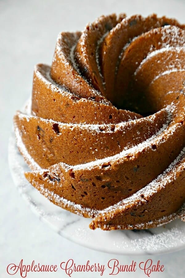 This Applesauce Cranberry Bundt Cake from CookingInStilettos.com will be a showstopper at your next weekend brunch. This moist rich applesauce cake studded with dried cranberries and spices will win rave reviews from your friends and family | @CookInStilettos