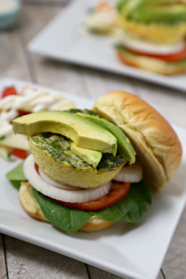 This Cheesy Breakfast Burger from CookingInStilettos.com is soon to be your favorite brunch recipe. A light as a feather quiche “burger” is nestled among fresh veggies in a pillowy bun for the perfect bite. | @CookInStilettos