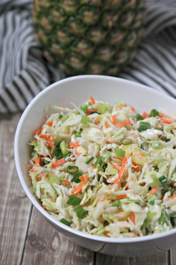 This easy Pineapple Slaw from CookingInStilettos.com will be a summertime favorite - sweet pineapple, spicy ginger & cabbage are tossed in a light yogurt dressing for the ultimate summer coleslaw | Cole Slaw | Pineapple | Healthy | BBQ | Cookout