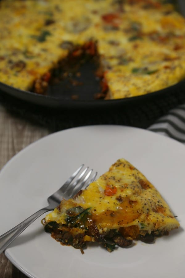 This easy one-pan BLT Frittata from CookingInStilettos.com is packed with the classic flavors of bacon, spinach and tomatoes along with mushrooms and cheese for the perfect breakfast, brunch or dinner bite | @CookInStilettos