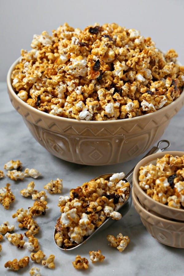 Bacon Bourbon Caramel Popcorn from CookingInStilettos.com is the ultimate salty sweet treat with a bit of a boozy kick. Crisp black pepper bacon is tossed with fluffy homemade popcorn in a buttery rich bourbon caramel and baked to perfection | @CookInStilettos