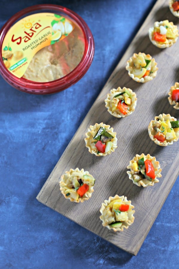 For a chic appetizer perfect for summer entertaining, these Garlicky Grilled Veggie Mini Tarts from CookingInStilettos.com are packed with flavor and so easy to make with Sabra Roasted Garlic Hummus. Vegetarian | Appetizers | Healthy | Lunch | Grilled