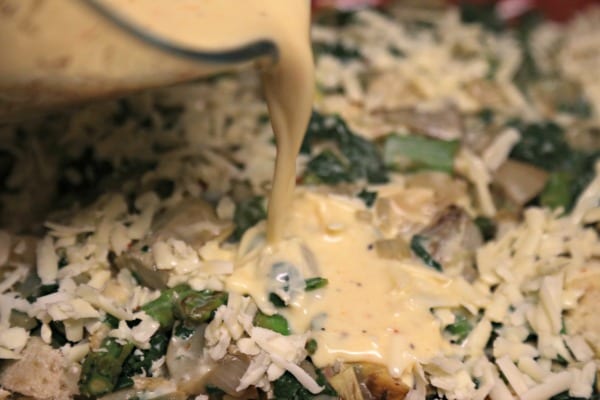 Spinach Artichoke and Asparagus Strata - Pouring the Custard | CookingInStilettos.com