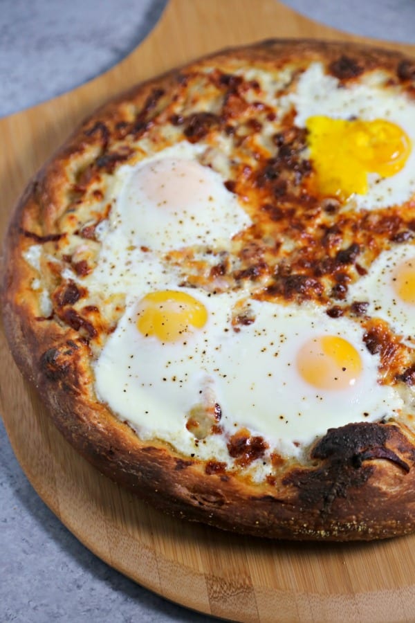 This Epic Bacon Croque Madame Pizza is the ultimate brunch pizza with layers of bacon, ham and cheese baked to perfection.  To take it over the top, bake a sunny side up egg (or a few) on it! Croque Madame | Homemade Pizza | Bacon Pizza | Bacon | Homemade Bechamel Sauce | Fontina | Gruyere | Cheese