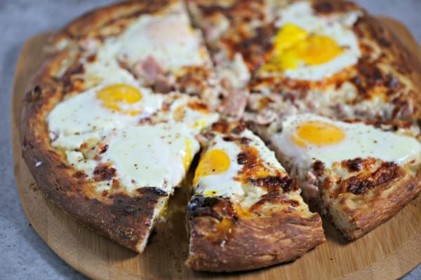 This Epic Bacon Croque Madame Pizza is the ultimate brunch pizza with layers of bacon, ham and cheese baked to perfection.  To take it over the top, bake a sunny side up egg (or a few) on it! Croque Madame | Homemade Pizza | Bacon Pizza | Bacon | Homemade Bechamel Sauce | Fontina | Gruyere | Cheese