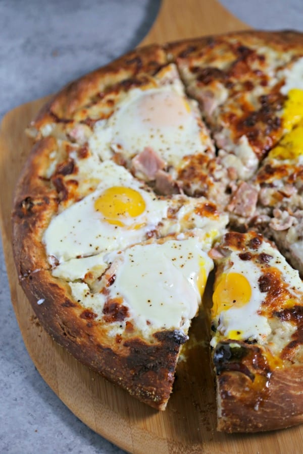 This Epic Bacon Croque Madame Pizza is the ultimate brunch pizza with layers of bacon, ham and cheese baked to perfection.  To take it over the top, bake a sunny side up egg (or a few) on it! Croque Madame | Homemade Pizza | Bacon Pizza | Bacon | Homemade Bechamel Sauce | Fontina | Gruyere | Cheese
