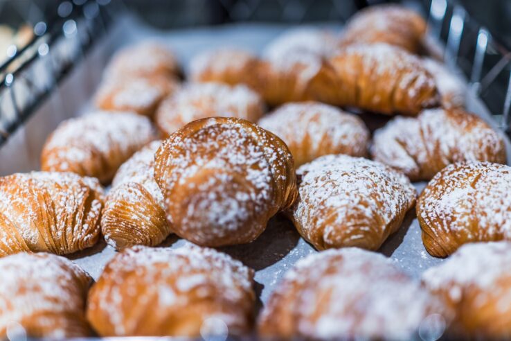 Sfogliatelle,Pastry,Display,In,Bakery,With,Powdered,Sugar,Macro,Closeup